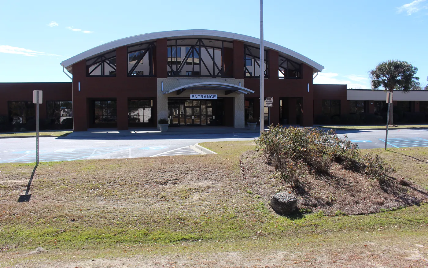 The brick main building of Bradwell Institute high school in Hinesville, with its arched entrance and flagpole