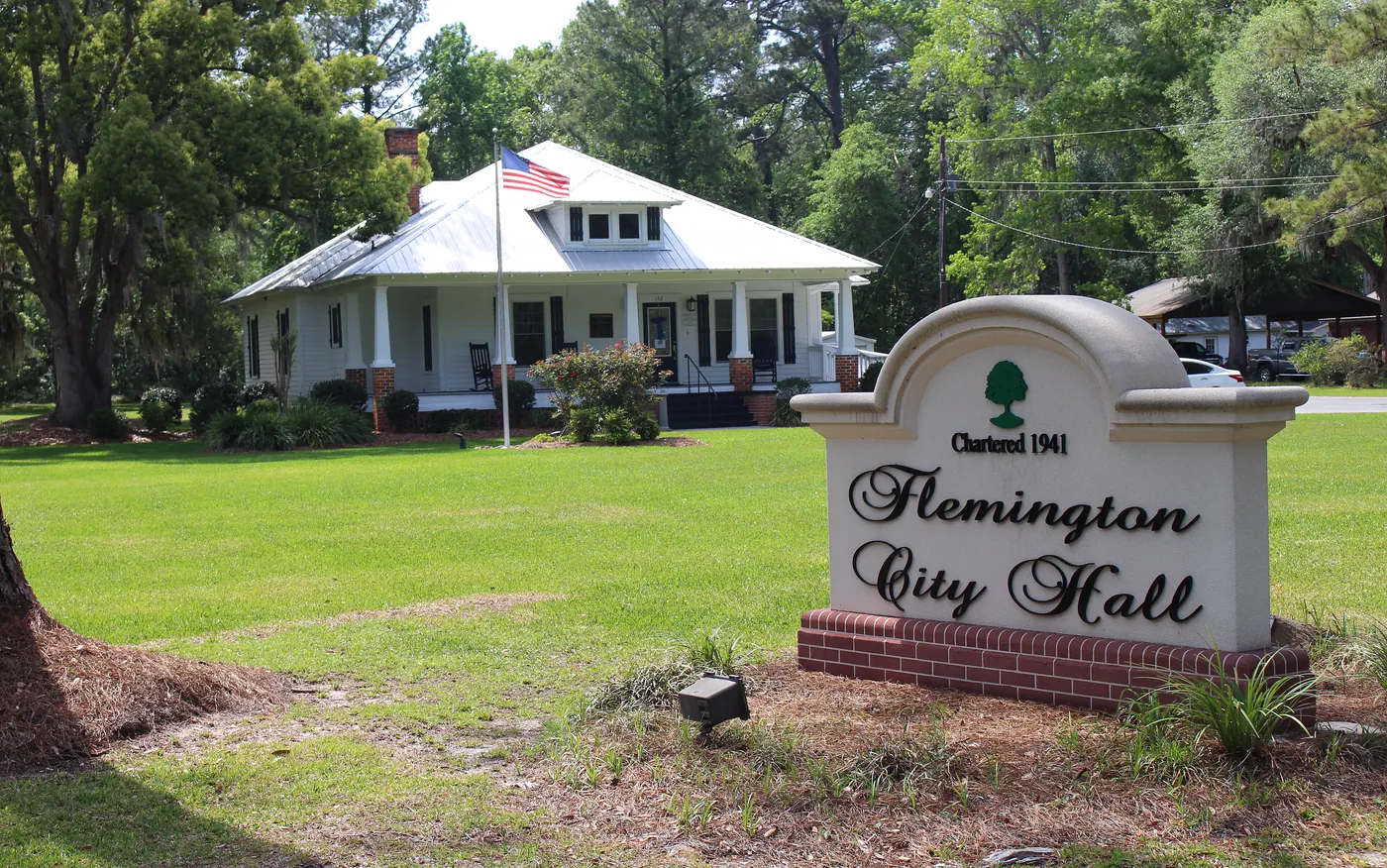 The Flemington City Hall sign, marked Chartered 1941, in front of the bungalow-style city hall in Flemington, Georgia