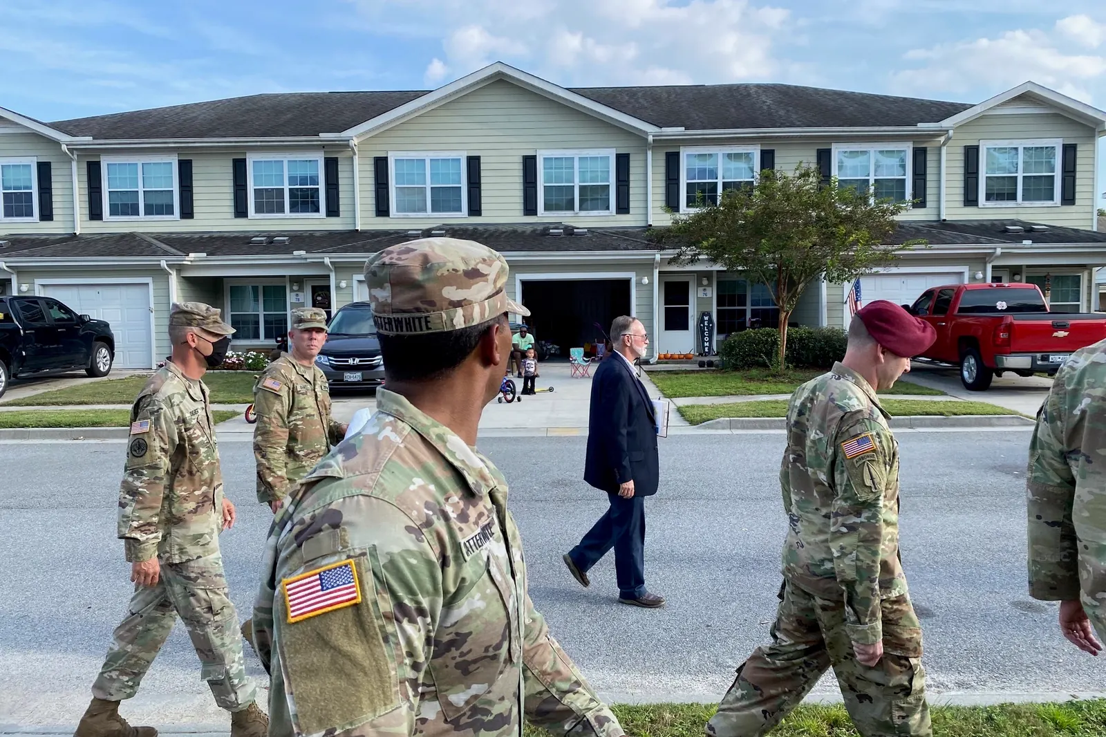 Installation leaders walking past two-story townhomes in Hunter Ridge